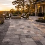 Beautiful backyard patio with pavers, outdoor seating, and fire pit at sunset.